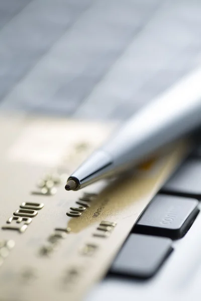 Closeup of credit cards and Ball pen on computer keyboard