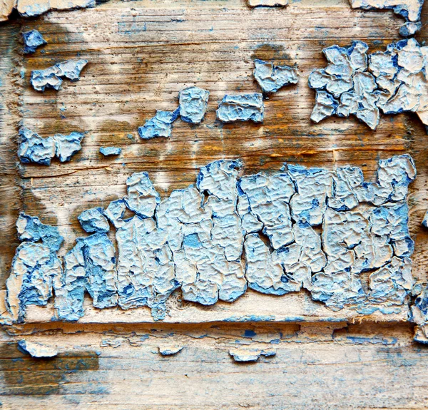 Dirty stripped paint in the blue wood door and rusty nail