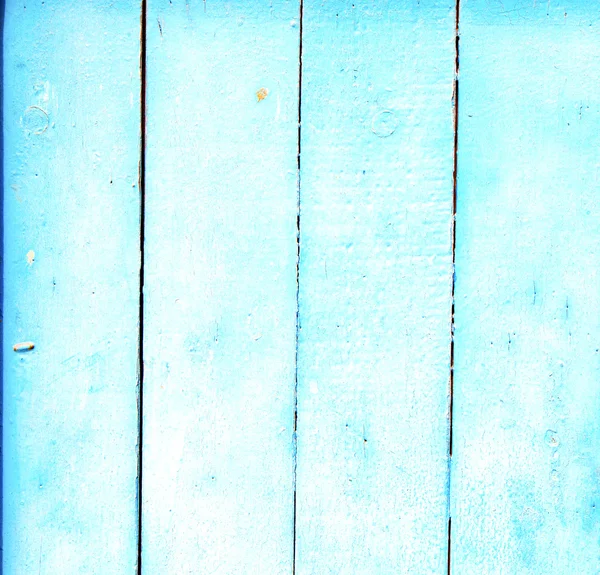 Stripped paint in the blue wood door and rusty nail