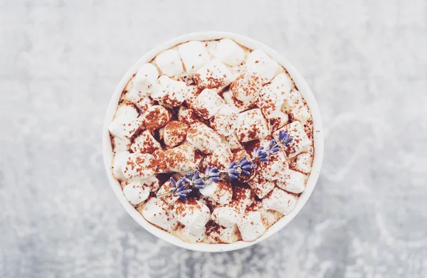 Hot chocolate with marshmallows and lavender at marble table