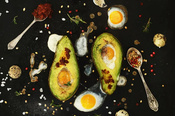Homemade appetizer -  baked avocado with quail eggs, black salt  and chili