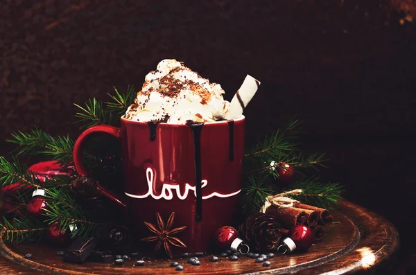 Winter decoration with hot chocolate in red mug, spices and xmas tree twigs