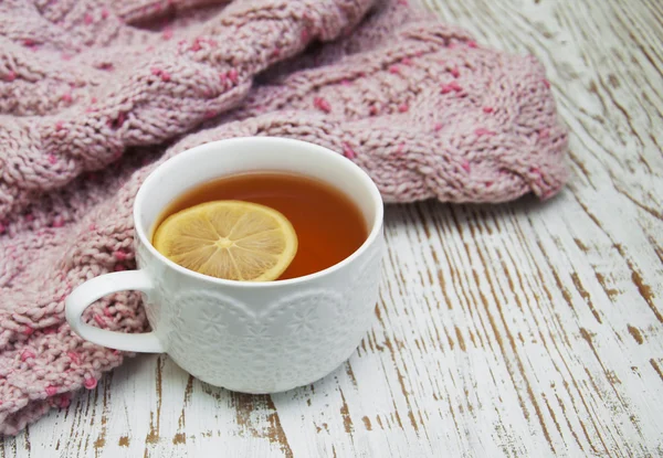 Cup of hot tea with lemon and scarf