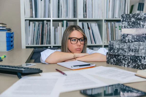 Exhausted secretary with folders stack in the desktop