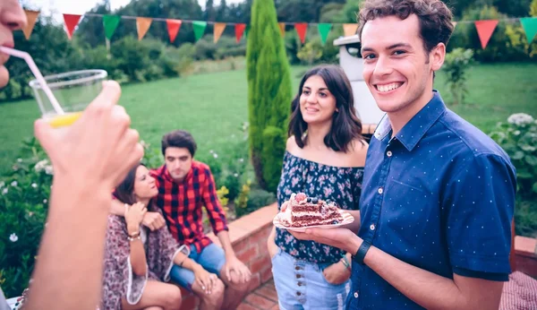 Man with piece of cake in a summer barbecue