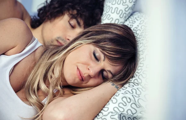 Young couple in love embracing lying over a bed