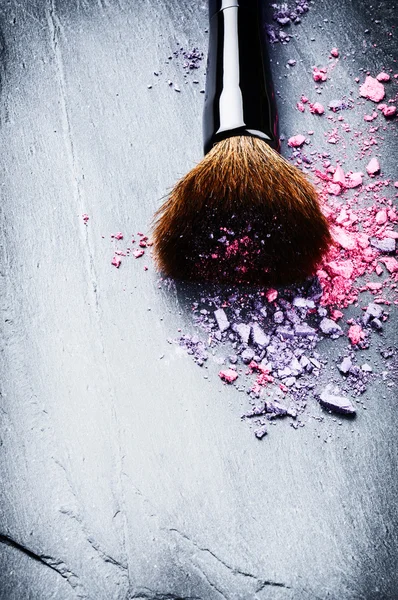 Makeup brush and crushed eye shadows