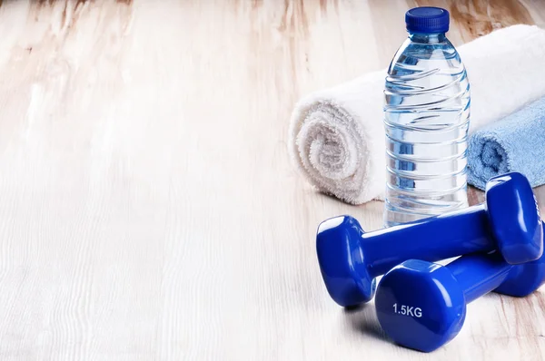 Fitness concept with dumbbells and water bottle