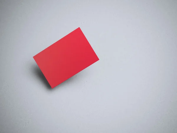 Red business card on gray floor.