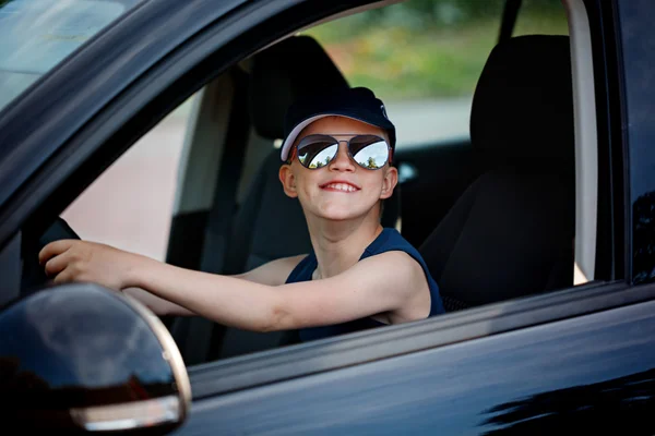 Cute little boy driving fathers car. Happy little boy  sitting in the car.