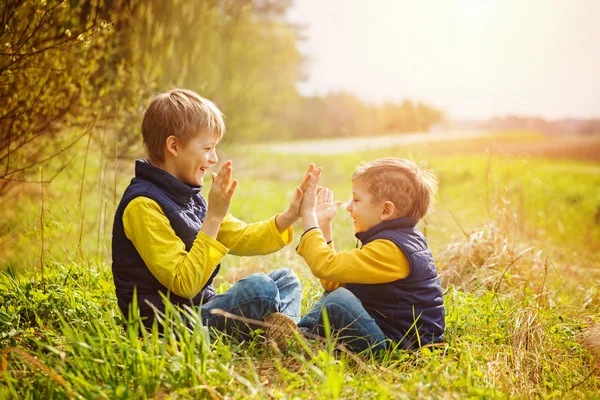 Happy two litte brothers having fun together  at the sunny day t