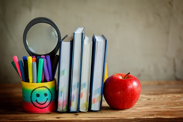 Group of school supplies and books and red apple over on background.School, stationary, equipment.