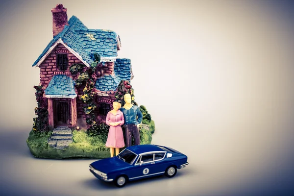 Couple with car and their new house