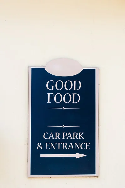 Restaurant sign advertising \'Good Food\' and sign for car park