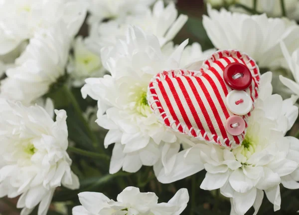 Love concept. Plush heart on bouquet of flowers