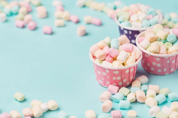 Small colored Marshmallows in blue table
