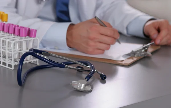 Male doctor write on the desk with test tube