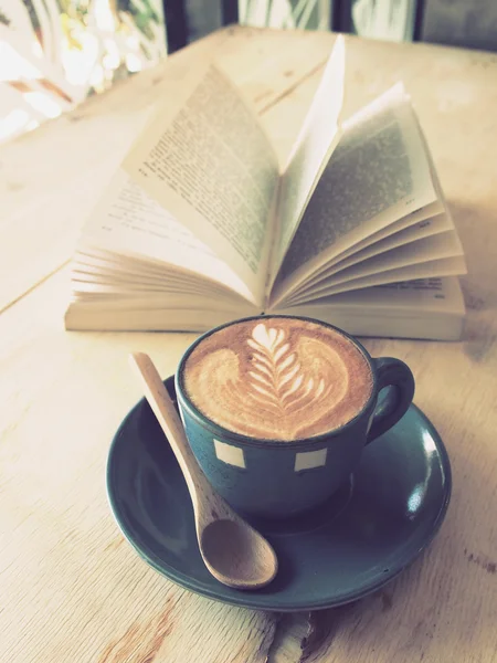 Cup of coffee with book in coffee shop vintage color