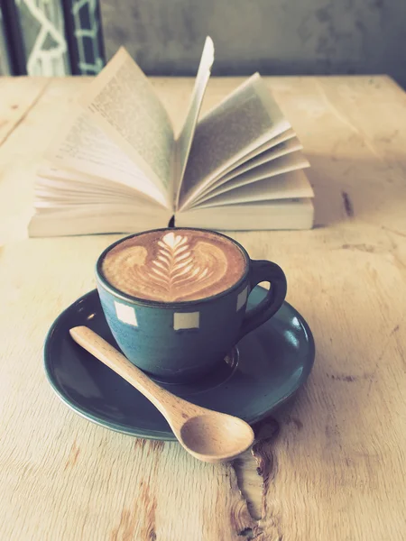 Cup of coffee with book in coffee shop vintage color