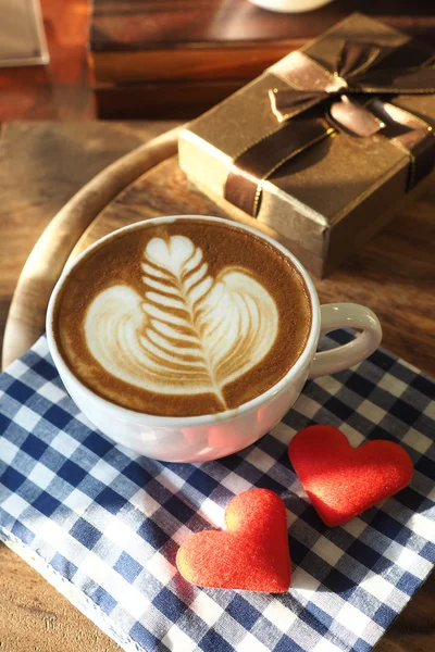 Vintage color tone of  cup of coffee with red heart on the table