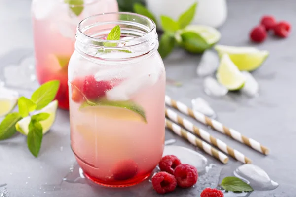 Cold green iced tea with lime and raspberry