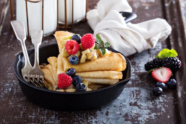 Thin pancakes with apples and fresh berry