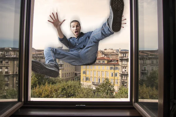 Young man falling down a window