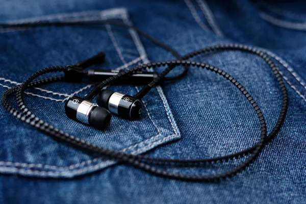 Headphones, mobile phone, tablet on pocket of jeans. Macro with blur and soft focus.