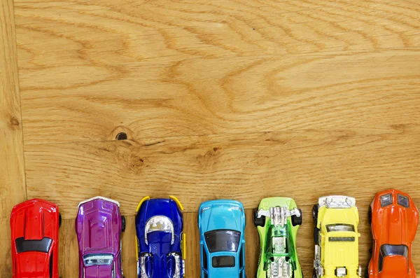 Miniature cars lined up on a wooden floor