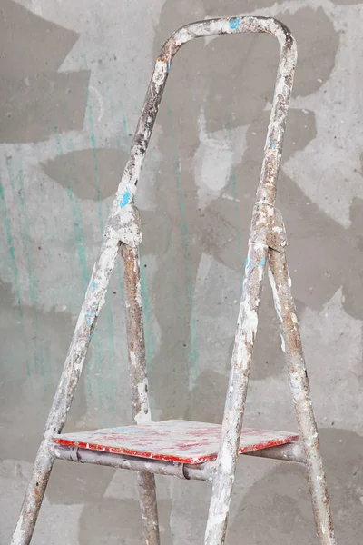 Old painted stucco ladder on concrete wall background