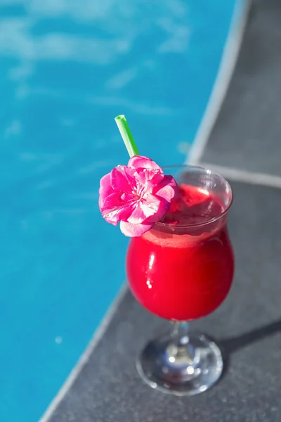 Glass of fresh watermelon smoothie juice drink swimming pool