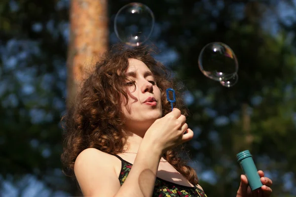 Young pretty woman blowing soap bubbles