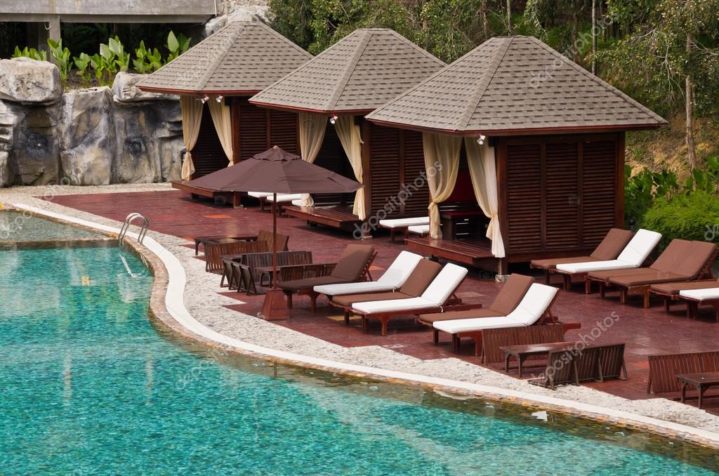 Hermosa piscina, silla y cabaña en complejo tropical — foto de ...