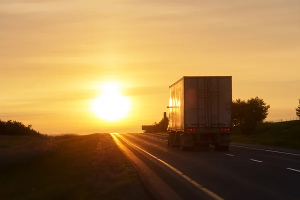 Trucking at sunrise on an empty road