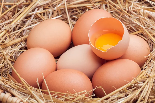 The eggs which are laid out in a basket with hay.