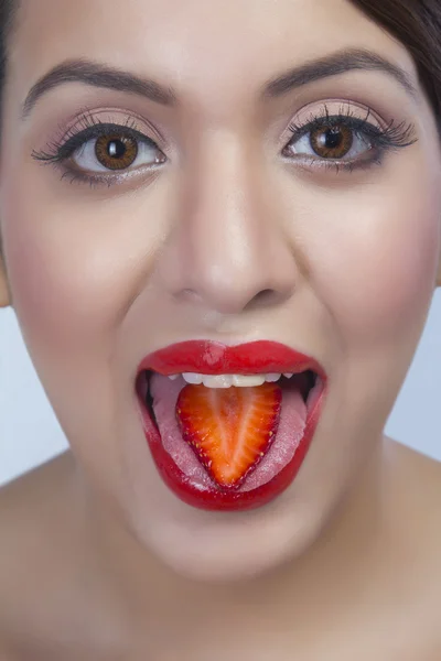 Woman eating a strawberry