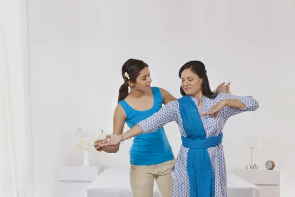 Daughter teaching mother to dance