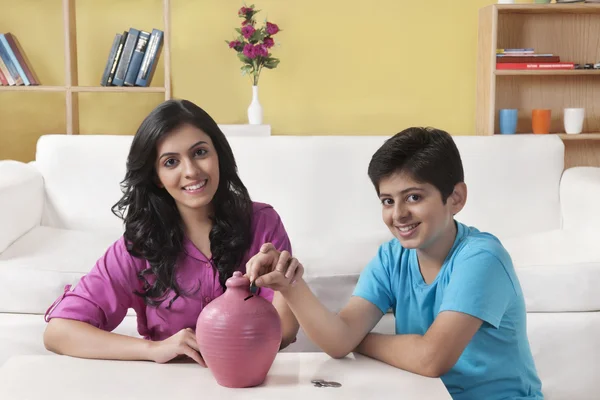 Indian Brother and sister inserting a coins