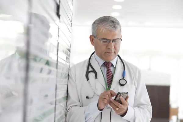 Doctor reading sms on phone