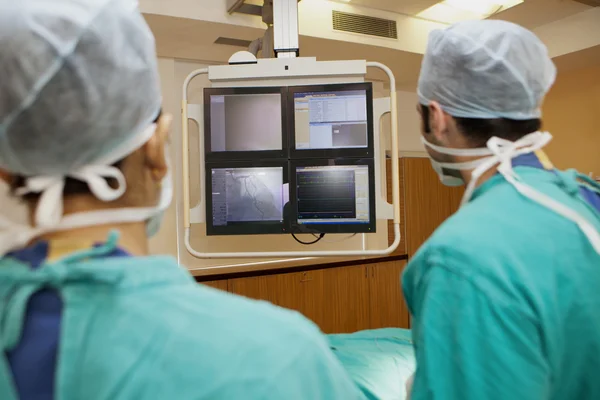 Surgeons looking at screen