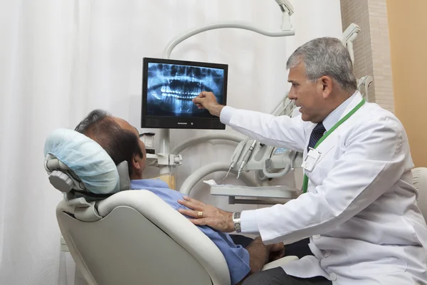 Dentist showing patient x-ray