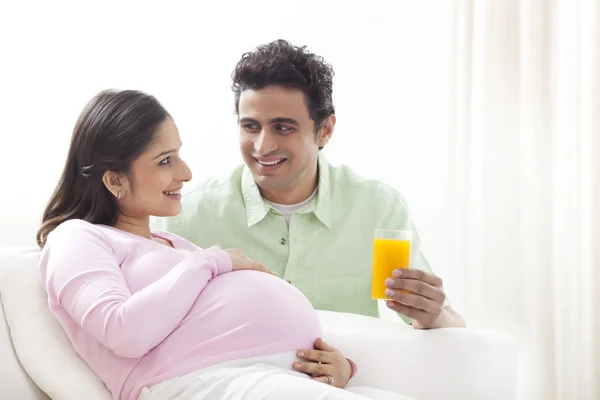 Man giving pregnant woman juice