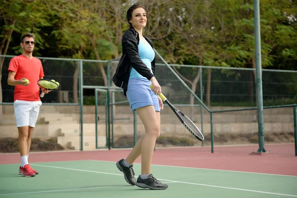 Coach teaching tennis to a woman