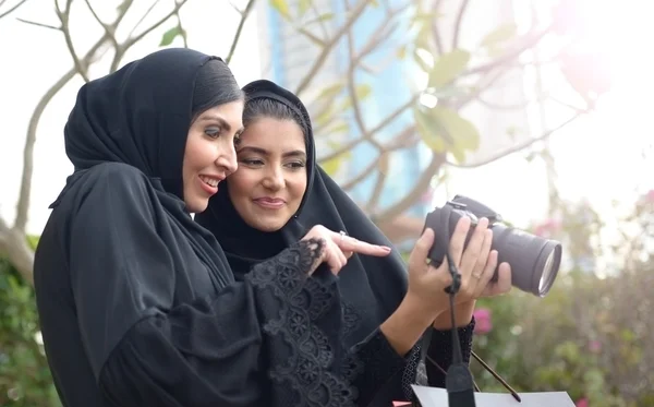 Emarati Arab women checking their photo in camera