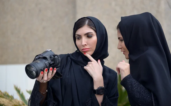 Emarati Arab women checking their photo in camera