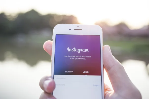 CHIANG MAI, THAILAND - JANUARY 02, 2015: A man trying to log in Instagram application using Apple iPhone 6. Instagram is largest and most popular photograph social networking site in the world.