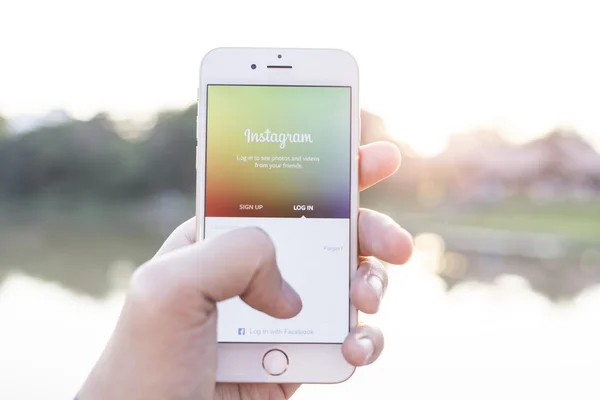 CHIANG MAI, THAILAND - JANUARY 02, 2015: A man trying to log in Instagram application using Apple iPhone 6. Instagram is largest and most popular photograph social networking site in the world.