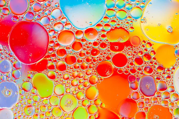 Oil drops in water on a coloured background