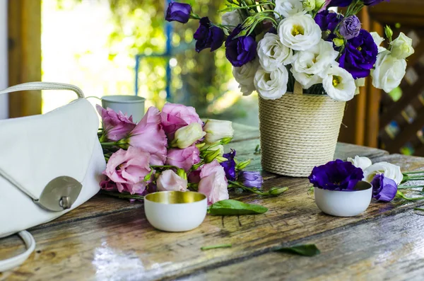 Beautiful bunch of white and purple roses in a vase on a wooden table.