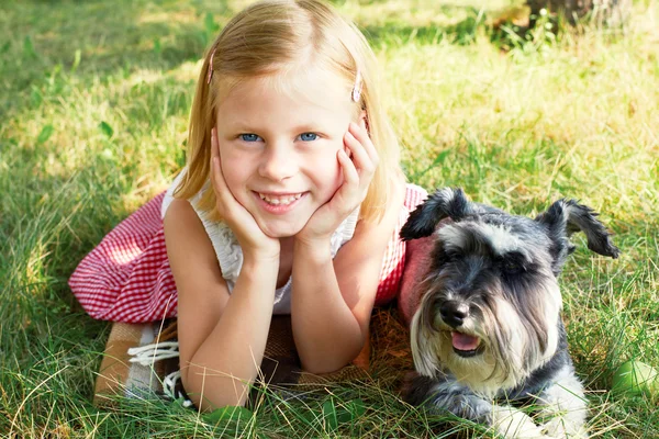 Happy cute little girl hugging her little dog